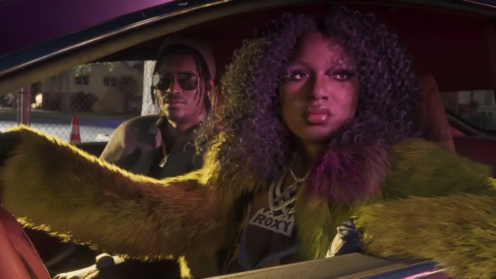 Roxy drives a car with Dre’Quan Priest in the passenger seat